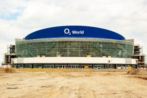 Die fertiggestellte O2-World-Arena 2008 mit Glasfassade und blauer Dachkonstruktion. Der Vorplatz der Mehrzweckhalle ist nicht bebaut.